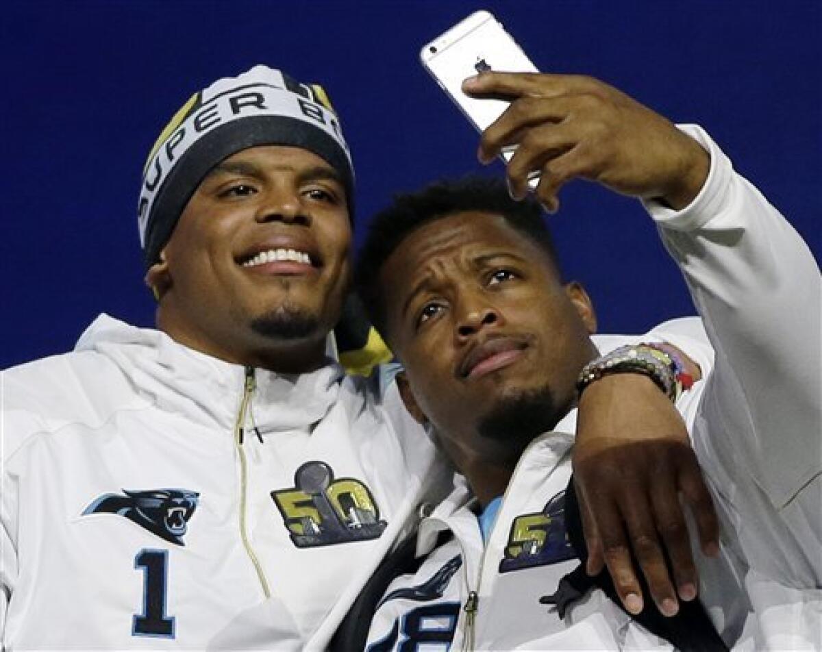 Jonathan Stewart (derecha) de los Panthers de Carolina se saca una selfie con el quarterback Cam Newton durante el día de prensa del Super Bowl el lunes 1 de febrero de 2016 (AP Foto/David J. Phillip)