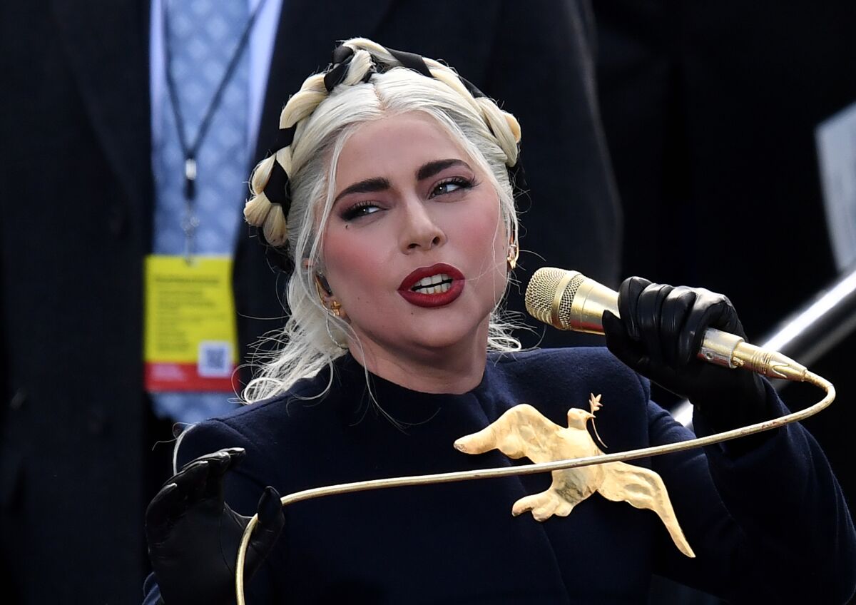 Lady Gaga is seen wearing a large gold bird pin against a black top during the inauguration at the U.S. Capitol on Wednesday.