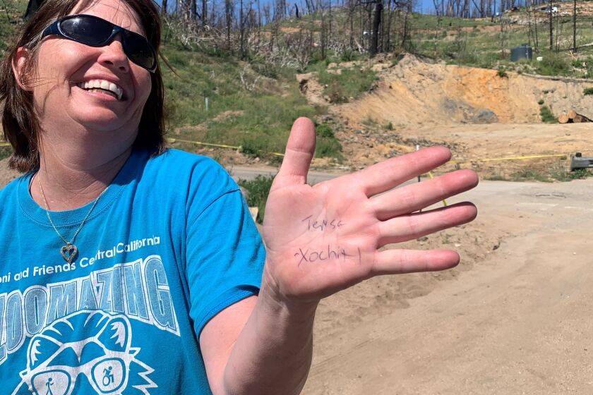 A woman holds out her palm, with the names Teresa and Xochitl written on it