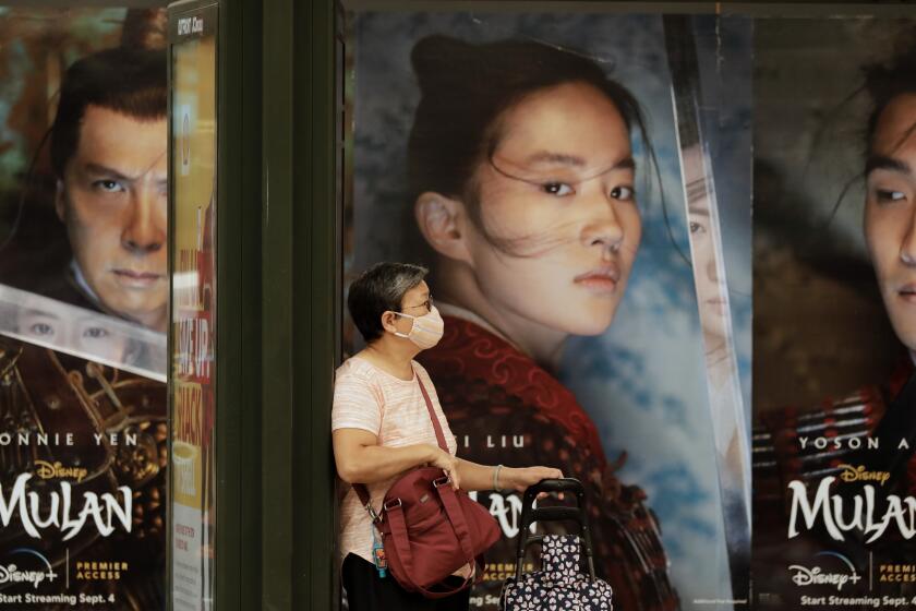 LOS ANGELES, CA - SEPTEMBER 10: Movie posters look back at a waiting bus passenger on Broadway in Chinatown on Thursday, Sept. 10, 2020 in Los Angeles, CA. (Myung J. Chun / Los Angeles Times)