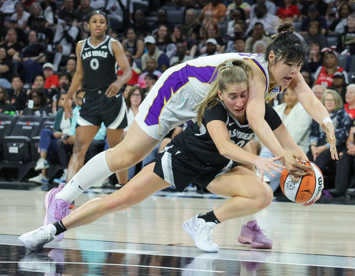 Aces guard Kate Martin tries to keep Sparks center Li Yueru from getting to a loose ball during their game Saturday.