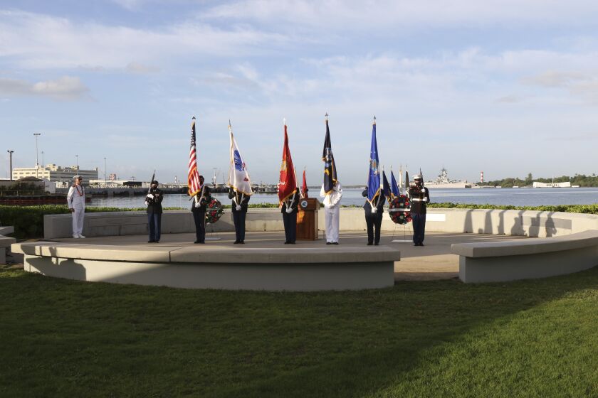 A military color guard participates in a ceremony to mark the anniversary of the attack on Pearl Harbor, Monday, Dec. 7, 2020, in Pearl Harbor, Hawaii. Officials gathered in Pearl Harbor to remember those killed in the 1941 Japanese attack, but public health measures adopted because of the coronavirus pandemic meant no survivors were present. The military broadcast video of the ceremony live online for survivors and members of the public to watch from afar. A moment of silence was held at 7:55 a.m., the same time the attack began 79 years ago. (AP Photo/Caleb Jones, Pool)