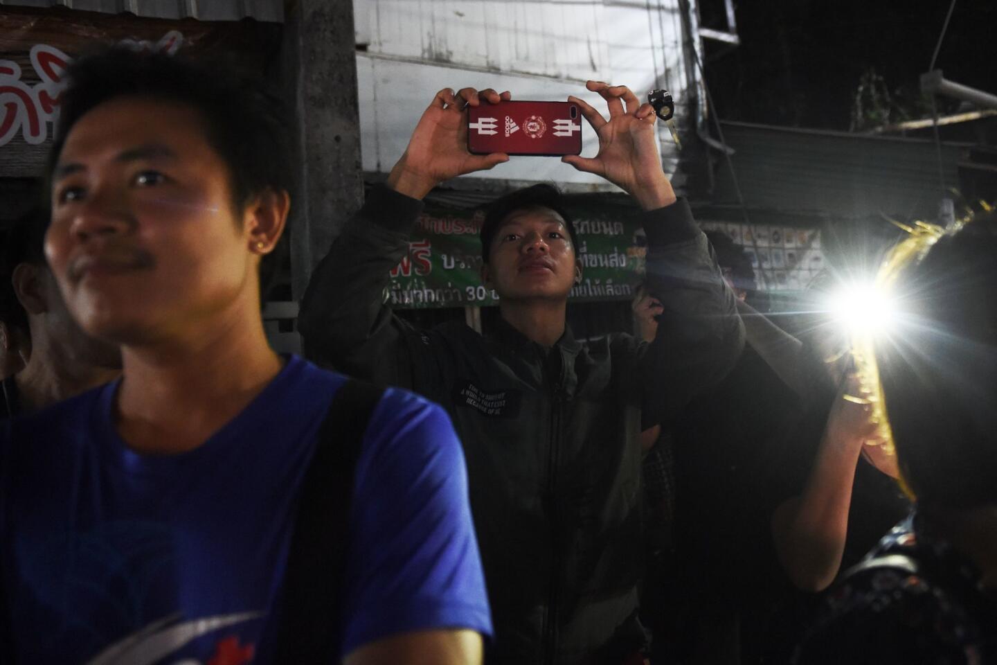 A man uses his mobile phone to take pictures July 10 near a hospital where the members of a youth soccer team and their coach were treated after being rescued from a cave in northern Thailand.