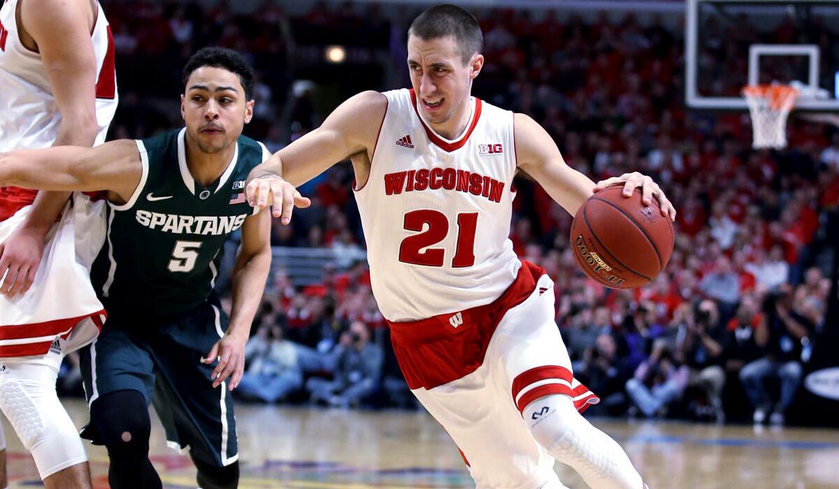 Wisconsin's Josh Gasser drives on Michigan State's Bryn Forbes during the first half of the Big Ten Conference tournament championship on Sunday.
