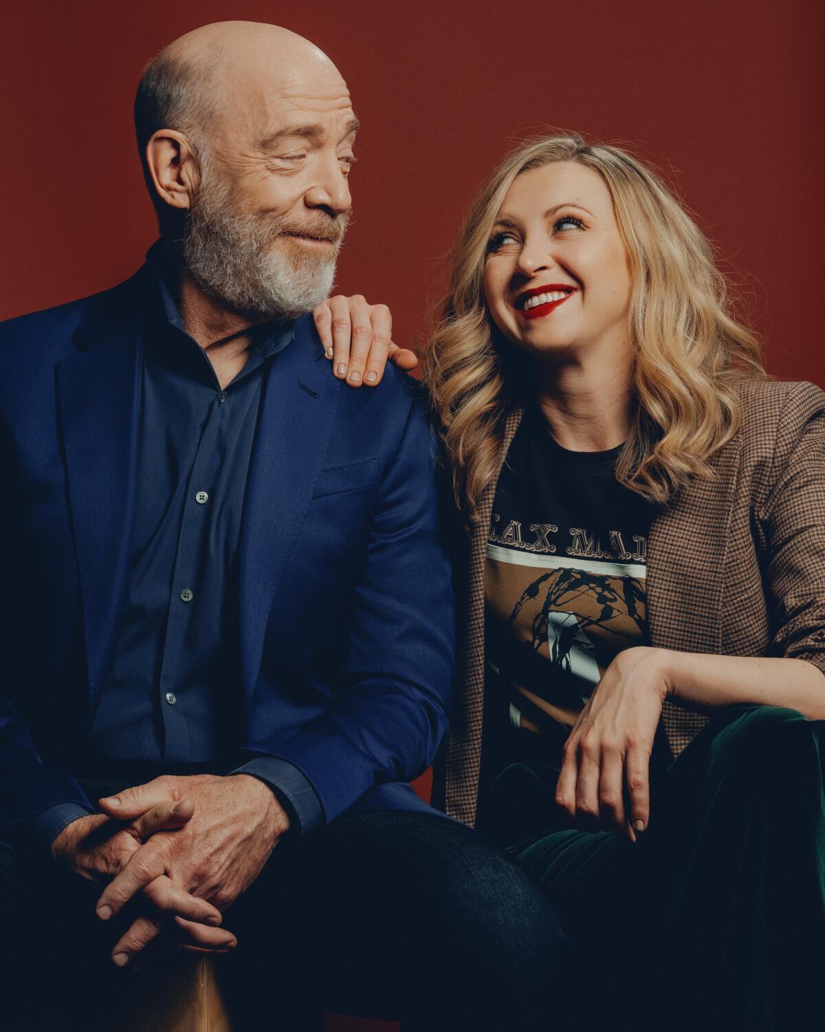 J.K. Simmons and Nina Arianda smile at each other.