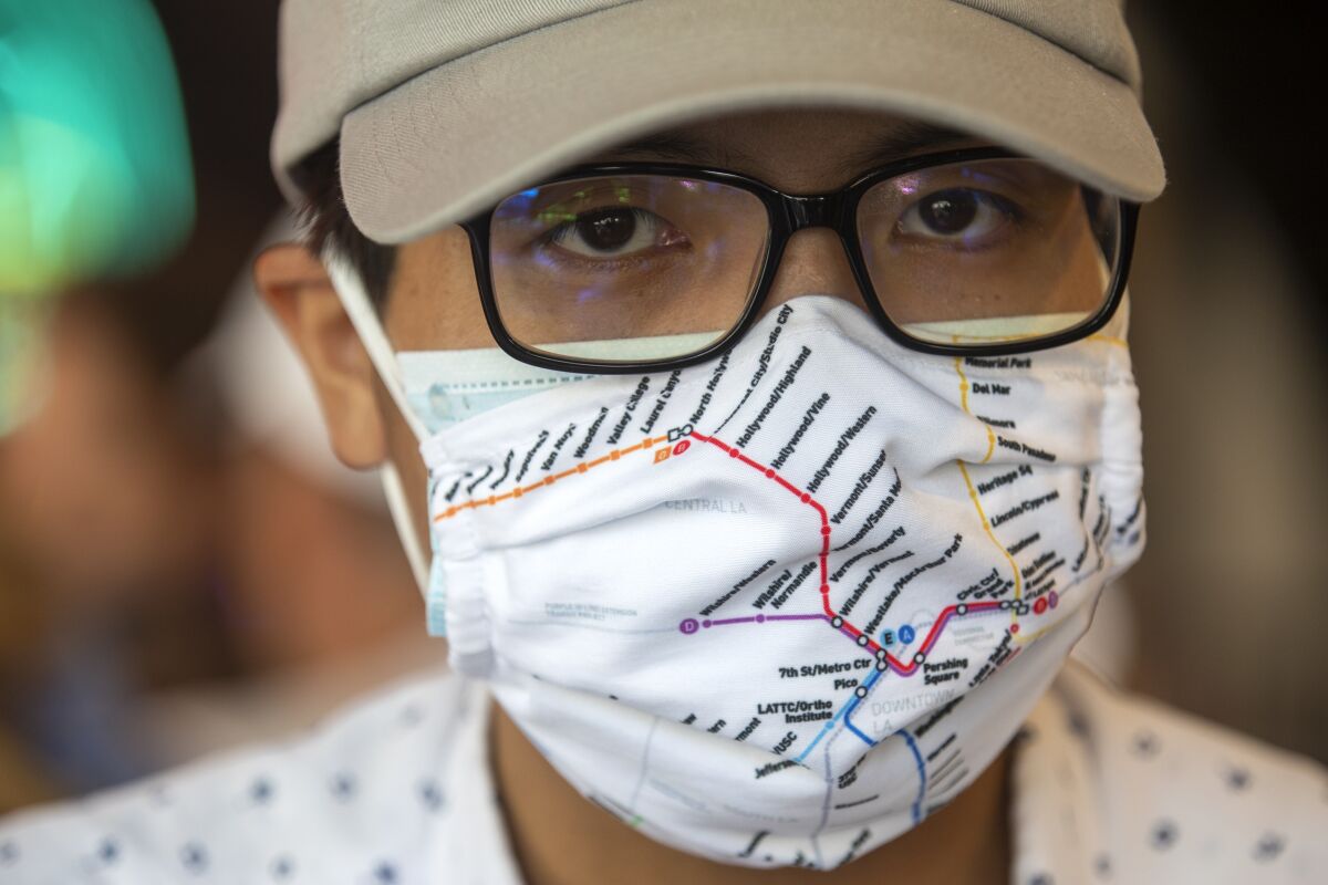 Transit "superfan" Kenny Uong wears a mask showing a map of Metro rail lines.