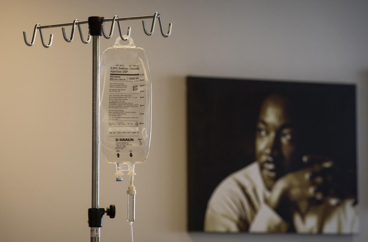 An IV bag hangs near a portrait of the Rev. Martin Luther King Jr.