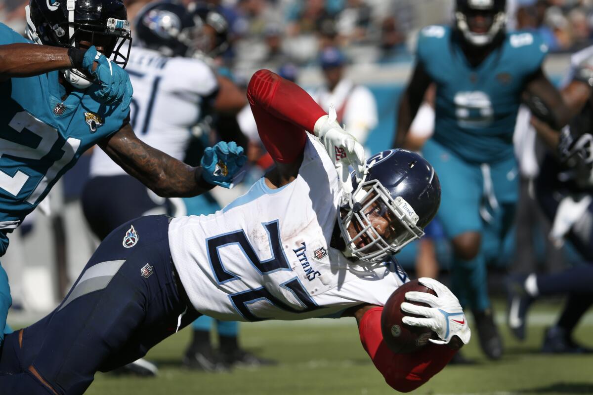Tennessee Titans running back Derrick Henry (22) dives for a touchdown past Jacksonville Jaguars cornerback Nevin Lawson (21) during the second half of an NFL football game, Sunday, Oct. 10, 2021, in Jacksonville, Fla. (AP Photo/Stephen B. Morton)