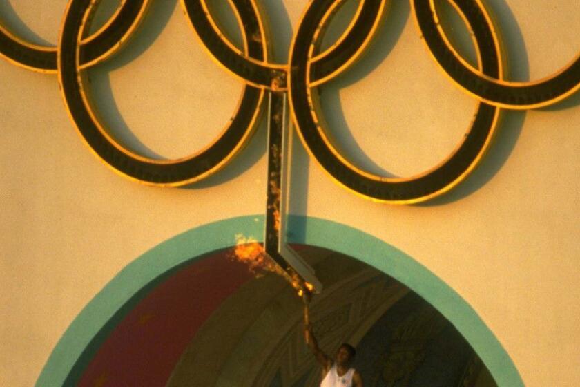 27 Jul 1984: Rafer Johnson of the USA holds the Olympic Torch after lighting the Olympic flame at the climax of the opening ceremonies for the 1984 Olympic Games at the Coliseum in Los Angeles, California.