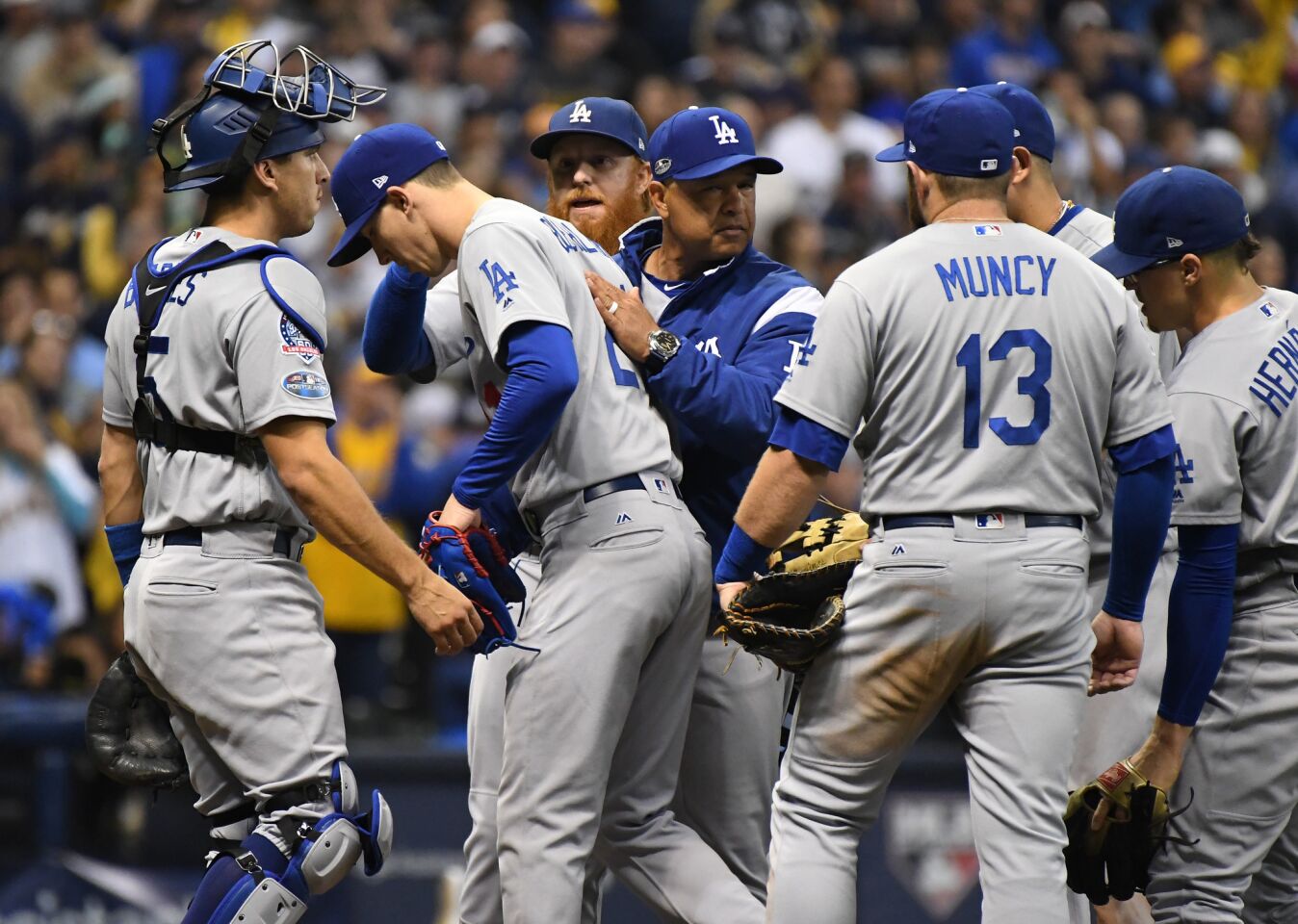 Dodgers manager Dave Roberts pats Walker Buehler after taking him out of the game in the fifth inning.