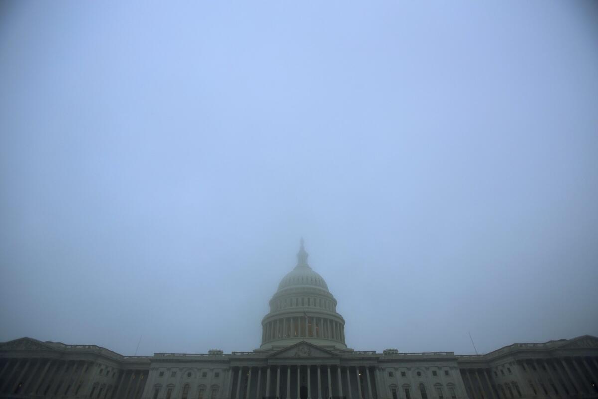 The US Capitol is shrouded in a dense morning fog in Washington DC.