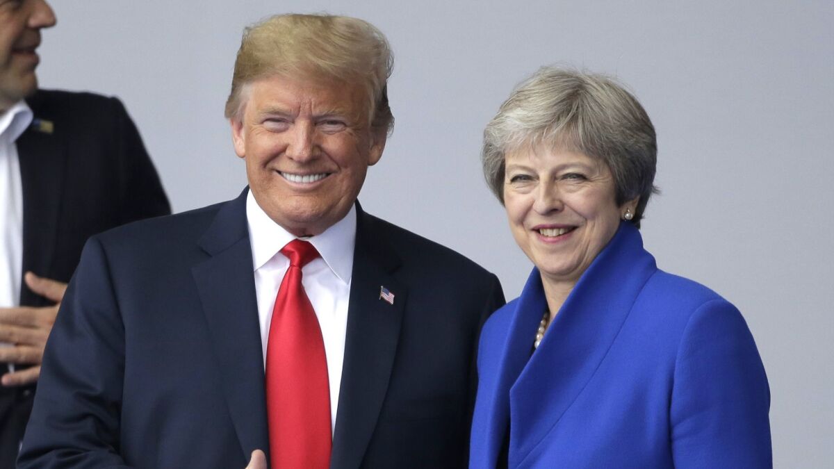 President Donald Trump, left, talks to British Prime Minister Theresa May during a summit of heads of state and government at NATO headquarters in Brussels.