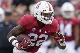 Stanford running back E.J. Smith carries the ball and plunges forward against USC last season
