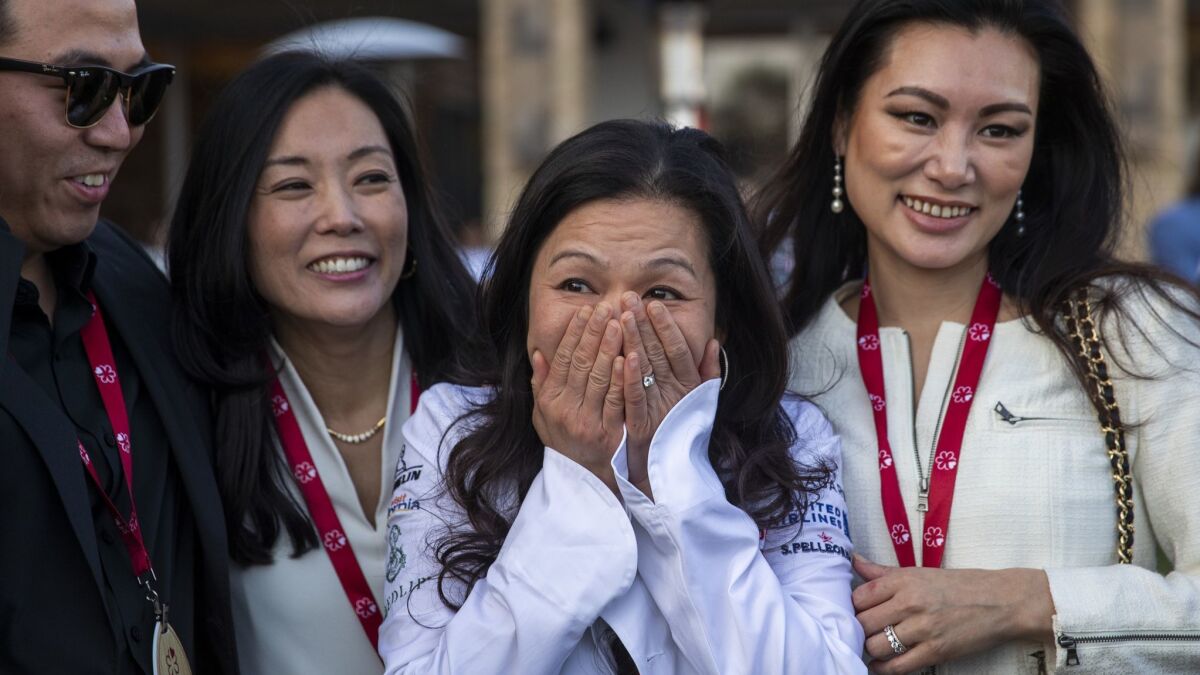 Chef Niki Nakayama, center, celebrates after her restaurant, n/naka, was awarded two Michelin stars during a live reveal of the 2019 California Michelin Guide in Huntington Beach.