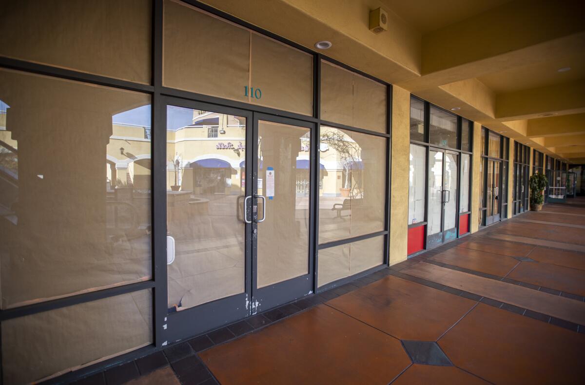 Windows of empty commercial spaces are lined with paper