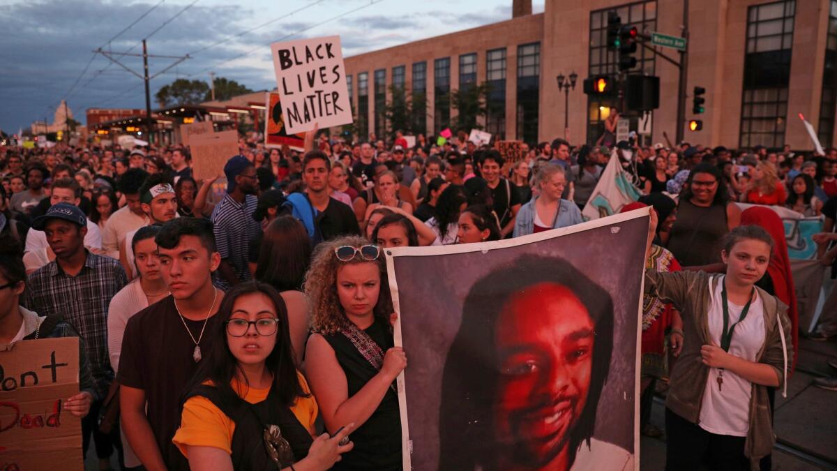 Supporters of Philando Castile hold a portrait of him as they march in St. Paul, Minn., on June 16.