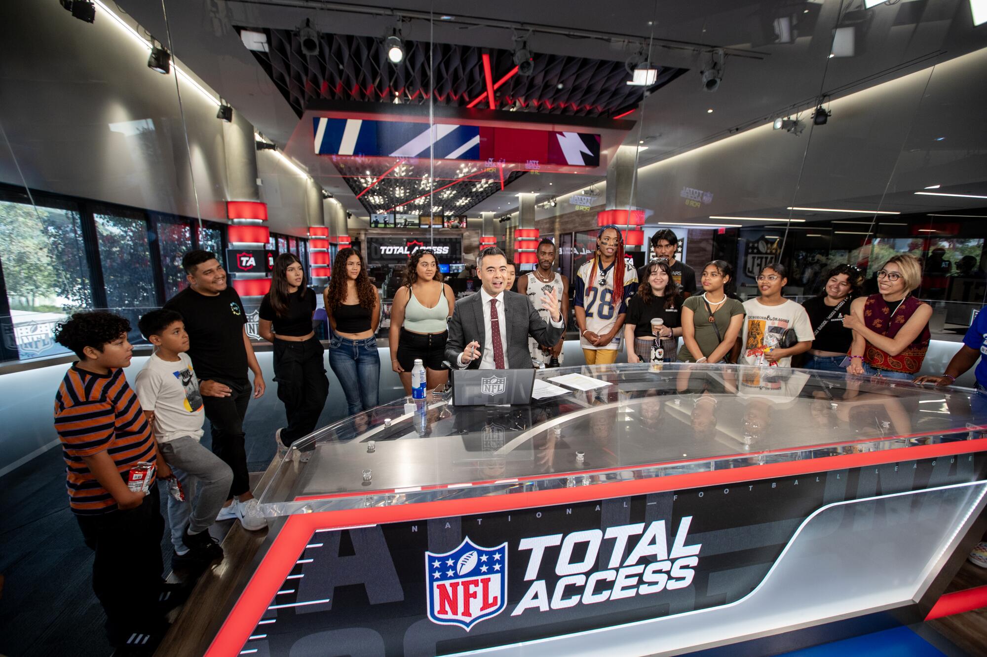 Rainbow Labs students, take photos w Mike Yam, NFL network host, of NFL Total Access program in the newsroom at NFL Studios