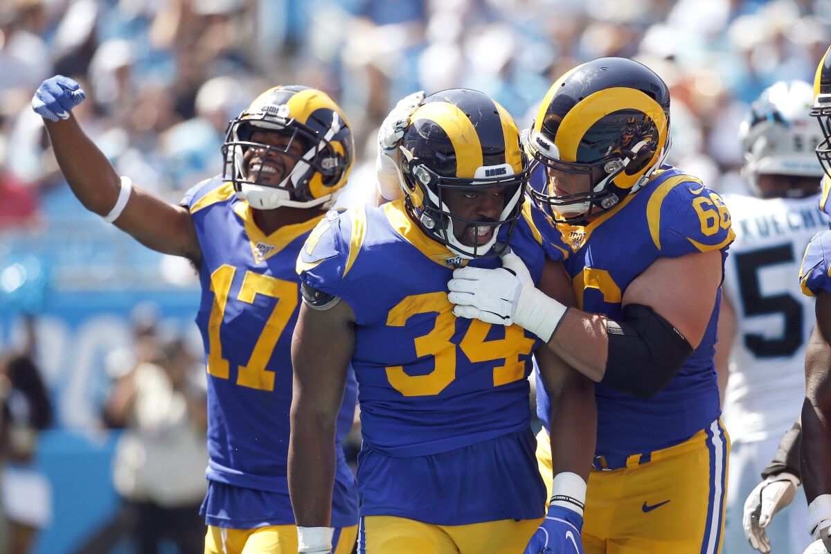 Rams running back Malcolm Brown (34) is congratulated by center Austin Blythe (66) and wide receiver Robert Woods (17) following Brown's touchdown against the Carolina Panthers during a September game last season in Charlotte.
