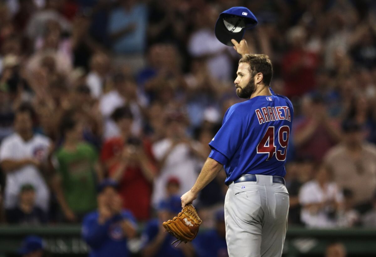 FILE - Chicago Cubs starting pitcher Jake Arrieta tips his cap as he gets a standing ovation from Red Sox fans after carrying a no-hitter to the eighth inning of a baseball game at Fenway Park in Boston, Monday, June 30, 2014. Boston Red Sox's Stephen Drew broke up his bid with a single in the eighth inning. Arrieta, a key pitcher on the Chicago Cubs' 2016 World Series championship team, has decided to retire, in news announced Monday, April 18, 2022. (AP Photo/Charles Krupa, File)
