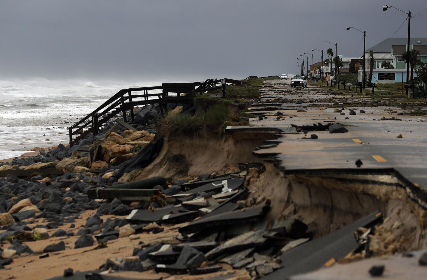 An official vehicle navigates debris as it passes along Highway A1A after it was partial washed away by Hurricane Matthew, Friday, Oct. 7, 2016, in Flagler Beach, Fla. Hurricane Matthew spared Florida's most heavily populated stretch from a catastrophic blow Friday but threatened some of the South's most historic and picturesque cities with ruinous flooding and wind damage as it pushed its way up the coastline.