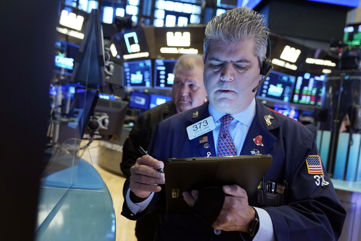 Trader John Panin, foreground, works on the floor of the New York Stock Exchange, Friday, July 23, 2021. 