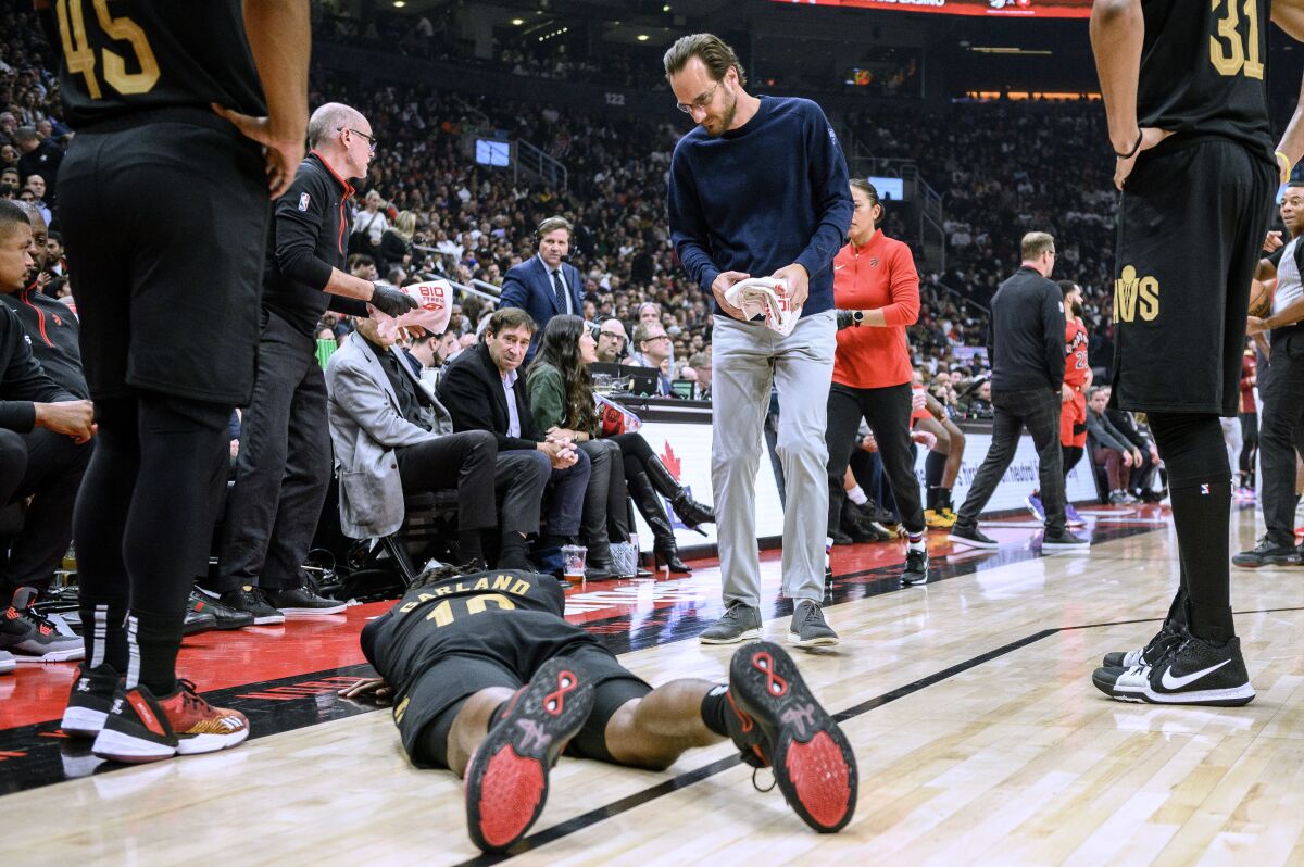 Cleveland Cavaliers guard Darius Garland (10) lies on the court after being injured during the first half of the team's NBA basketball game against the Toronto Raptors on Wednesday, Oct. 19, 2022, in Toronto. (Christopher Katsarov/The Canadian Press via AP)