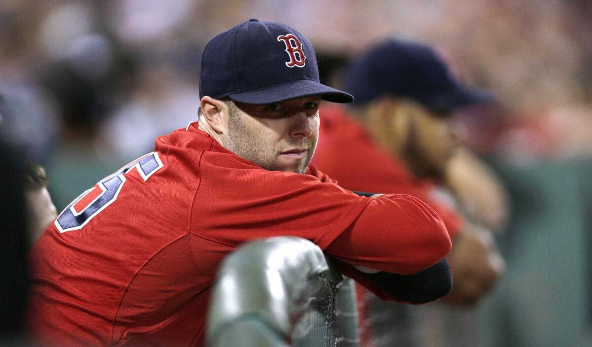 Boston Red Sox second baseman Dustin Pedroia watches from the dugout rail Friday at Fenway Park.