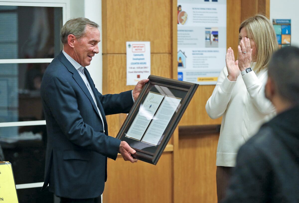 Newly appointed Mayor Sue Kempf, right, hands three-year, outgoing Mayor Bob Whalen, left, a proclamation for his service.