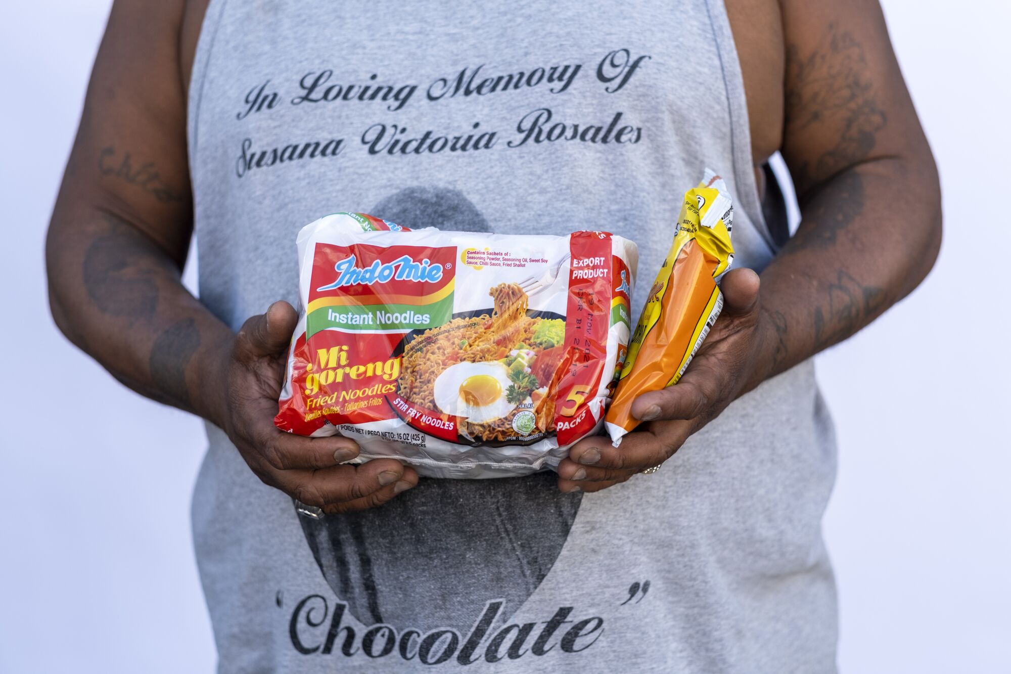 A man holds a package of noodles.
