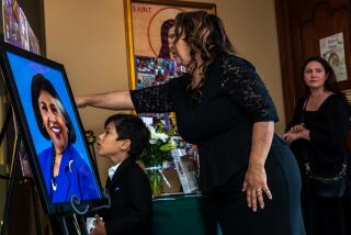  Sister Olga Molina Palacios with her 6-year-old son Moises Armando Palacios pays her respect at Gloria Molina's funeral.   