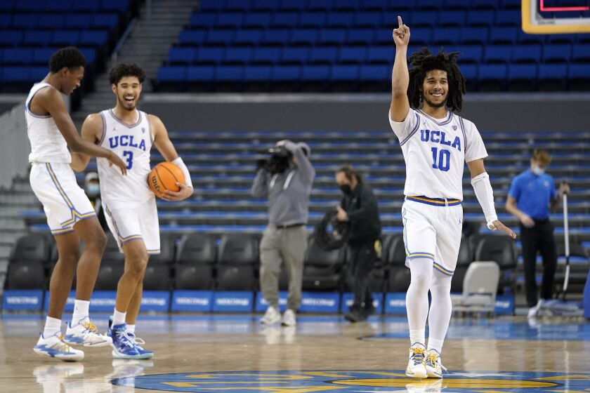 UCLA guard Tyger Campbell, right, celebrates along with guard Peyton Watson, left, and guard Johnny Juzang as they defeat Oregon State 81-65 in an NCAA college basketball game Saturday, Jan. 15, 2022, in Los Angeles. (AP Photo/Mark J. Terrill)