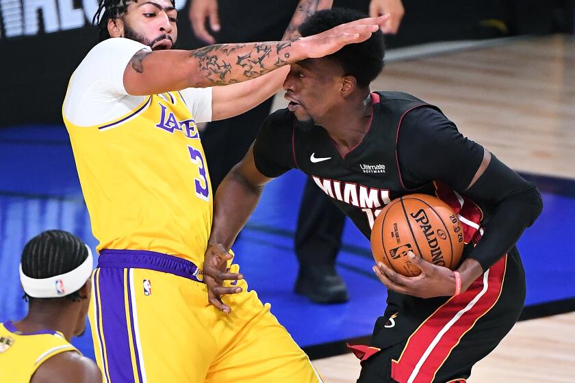 ORLANDO, FLORIDA OCTOBER 6, 2020-Heat's Bam Adebayo charges into Lakers Anthony Davis for a foul in the 1st quarter in Game 4 of the NBA FInals in Orlando Sunday. (Wally Skalij/Los Angeles Times)