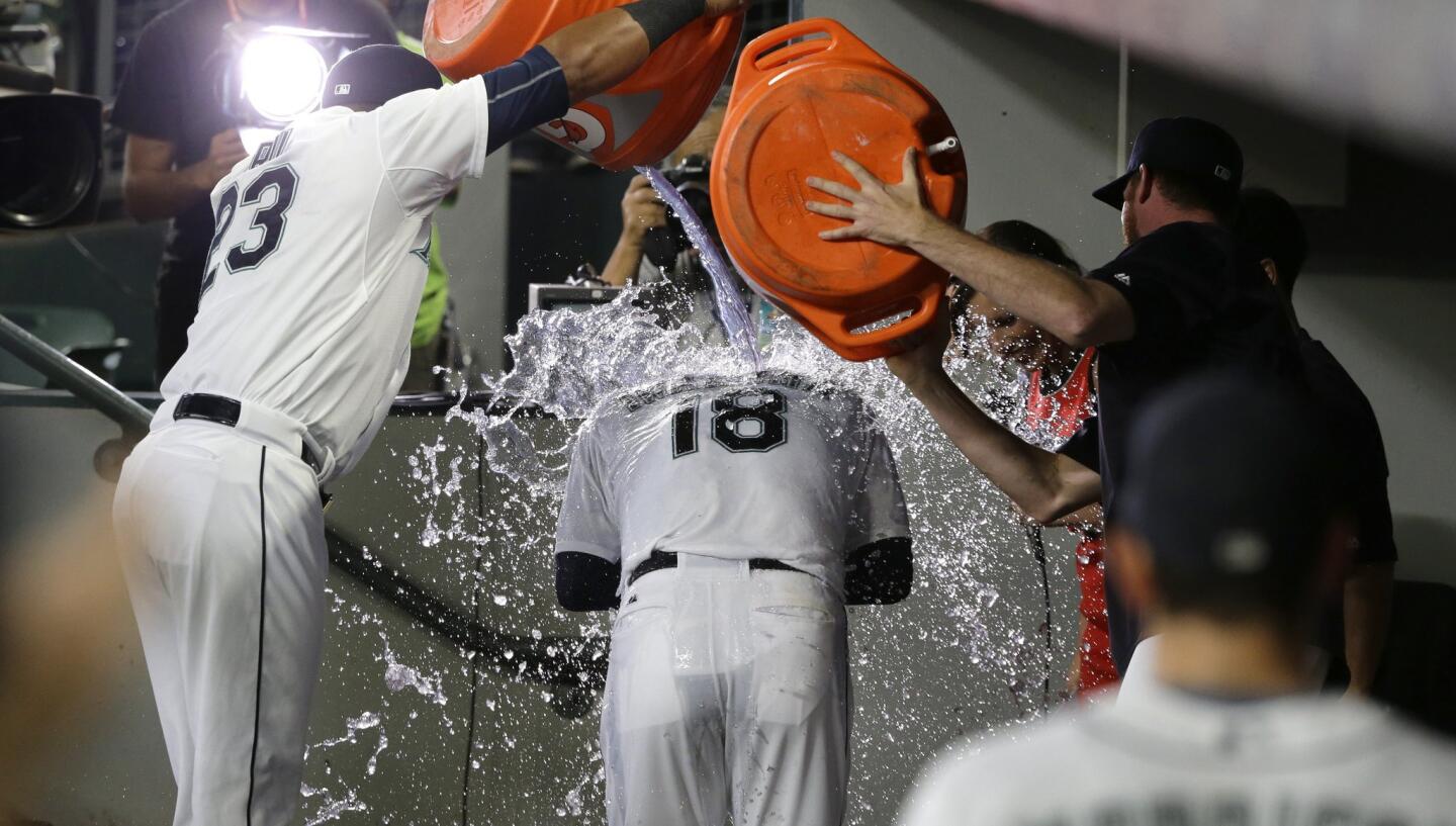 Seattle Mariners starting pitcher Hisashi Iwakuma (18) has water poured on him by teammates including Nelson Cruz, left, as he is interviewed after he threw a no-hitter against the Baltimore Oriole in a baseball game, Wednesday, Aug. 12, 2015, in Seattle. The Mariners beat the Orioles 3-0. (AP Photo/Ted S. Warren)
