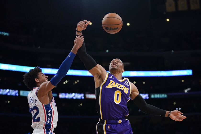 Philadelphia 76ers guard Matisse Thybulle (22) fouls Los Angeles Lakers guard Russell Westbrook (0) during the first half of an NBA basketball game in Los Angeles, Wednesday, March 23, 2022. (AP Photo/Ashley Landis)