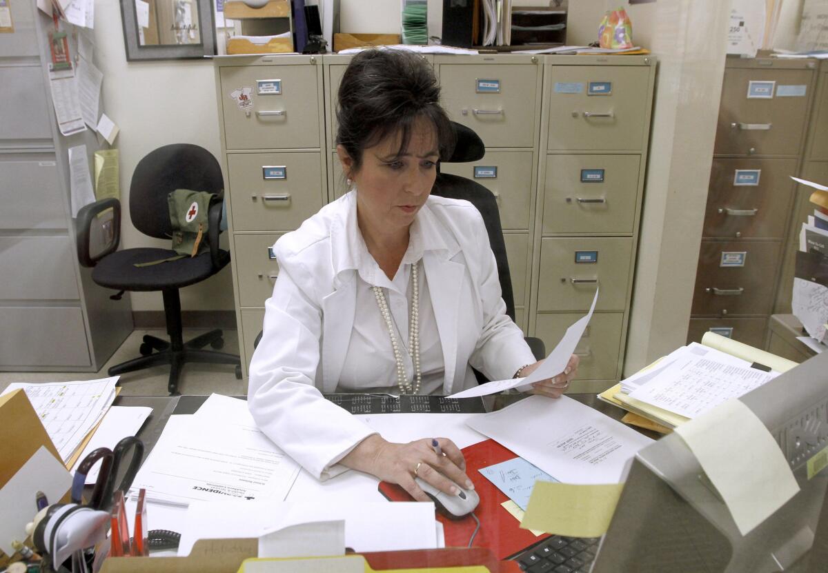 Burbank Unified School District lead nurse Lenora Aguilera works on paperwork as she tends to sick students at Burroughs High School in Burbank on Tuesday, April 8, 2014. Aguilera will see from 40 to more than 100 students a day for various illnesses at various district schools, and plans to request additional nursing staff for the district.