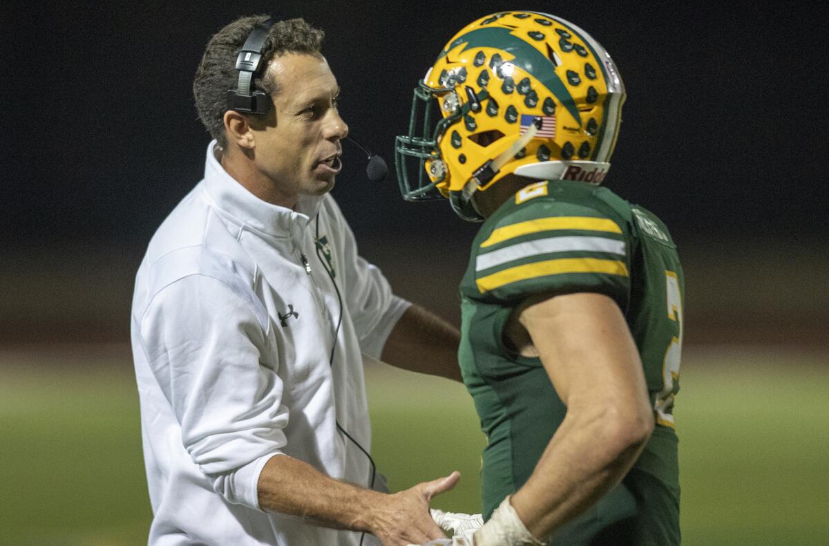 Edison coach Jeff Grady congratulates Mike Walters after he rushed for a four-yard touchdown in the fourth quarter against Heritage in the first round of the CIF Southern Section Division 3 playoffs on Friday at Huntington Beach High.
