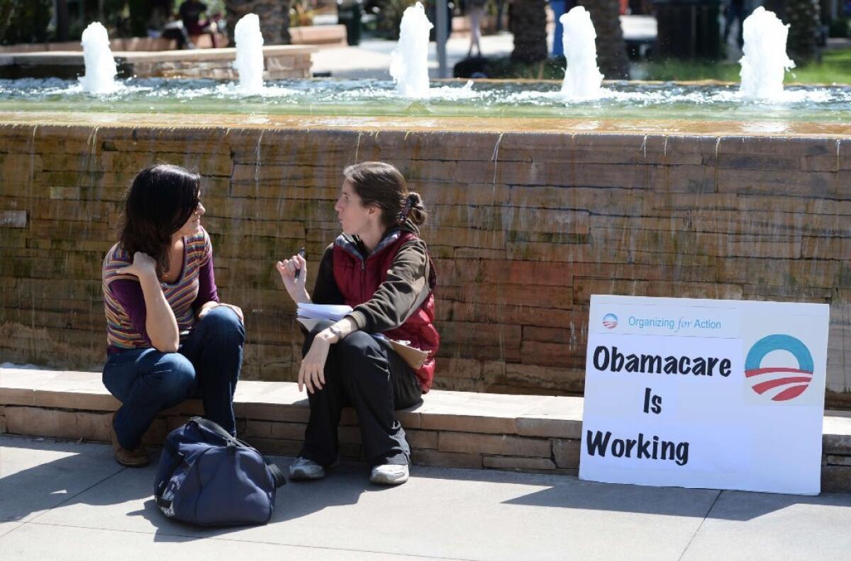 An Affordable Care Act supporter, right, is seen last year talking with a student about the law at Santa Monica City College.