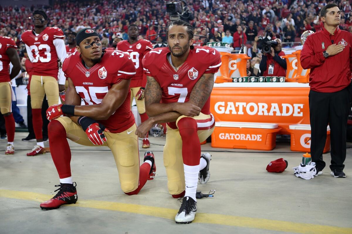 San Francisco 49ers Reid (35) & Kaepernick (7) take a knee during the National Anthem prior to their opener against the Rams.