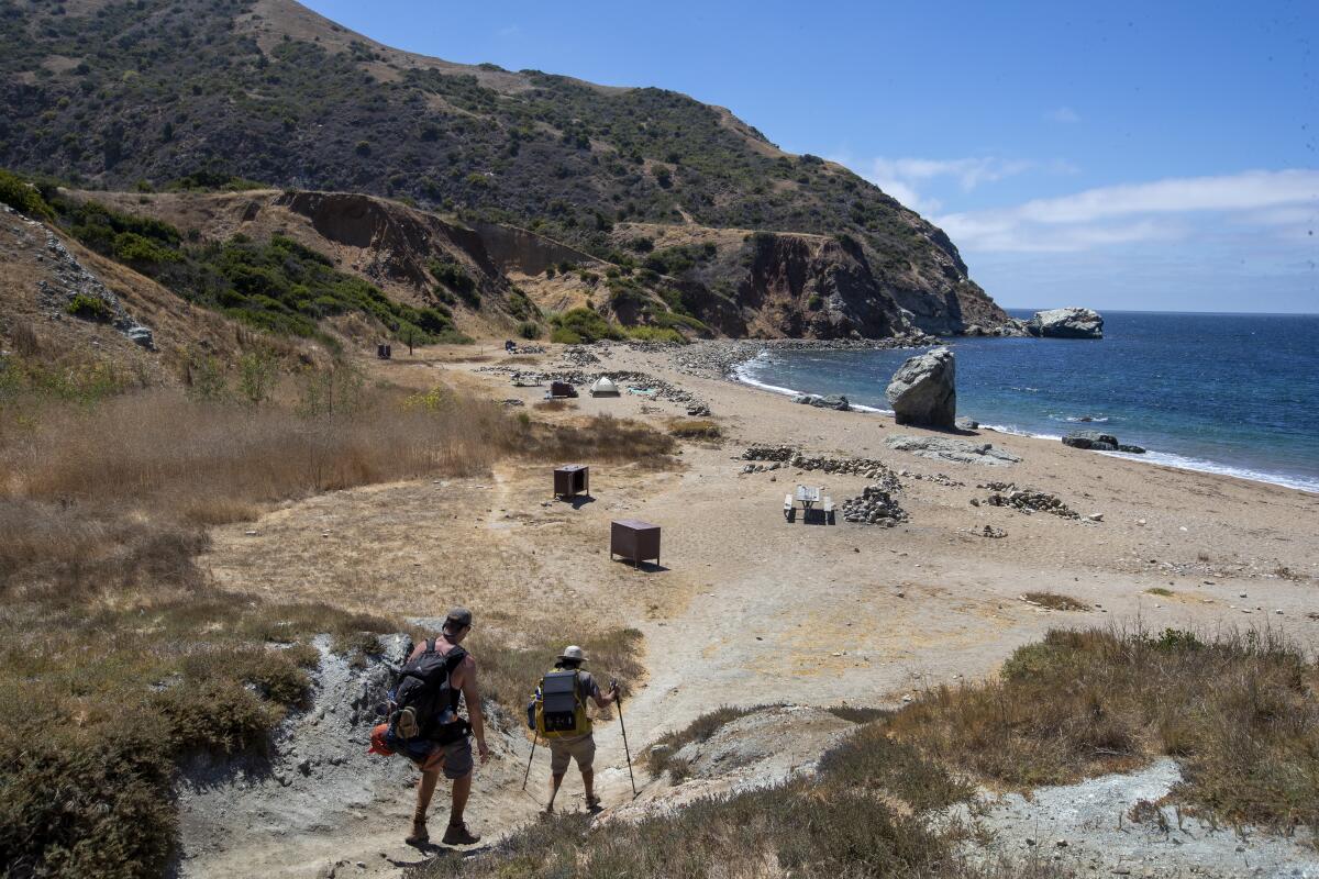 Hikers arrive at a campground at the beach