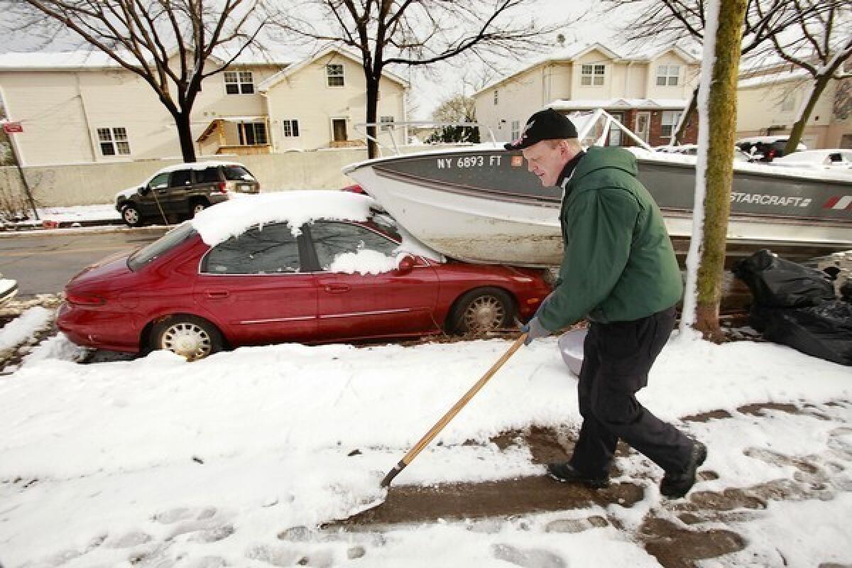 Danny Frost clears a sidewalk on Staten Island, N.Y., where many have evacuated and services remain out after Superstorm Sandy.