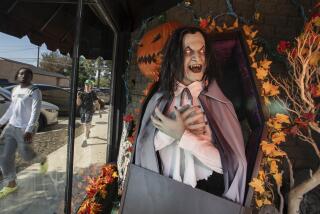 BURBANK, CA - October 10, 2022 - Customers walk past a window at the Halloween Town store Monday, Oct. 10, 2022 in Burbank, CA. (Brian van der Brug / Los Angeles Times)