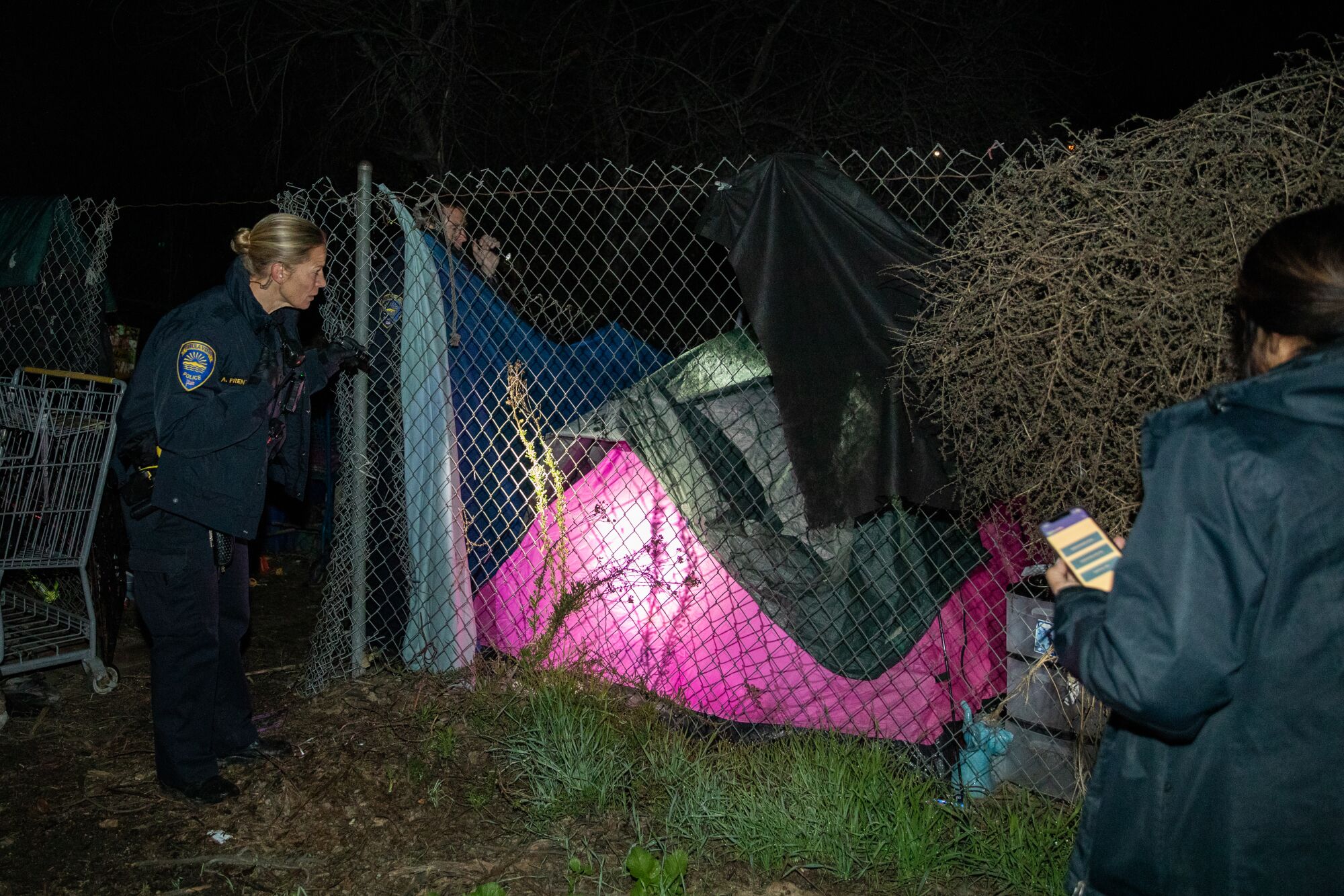 Police officer Alexa Frentzen checks if anyone is sleeping inside a tent while conducting the annual homeless count.