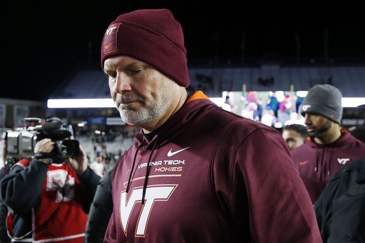 FILE - Virginia Tech head coach Justin Fuente walks off the field after losing to Boston College during an NCAA college football game, Friday, Nov. 5, 2021, in Boston. Virginia Tech and football coach Justin Fuente have mutually agreed to part ways with two games left in his sixth season with the Hokies. In a statement, athletic director Whit Babcock said co-defensive line coach and recruiting coordinator J,C. Price will lead the Hokies through their final two regular season games. (AP Photo/Michael Dwyer, File)