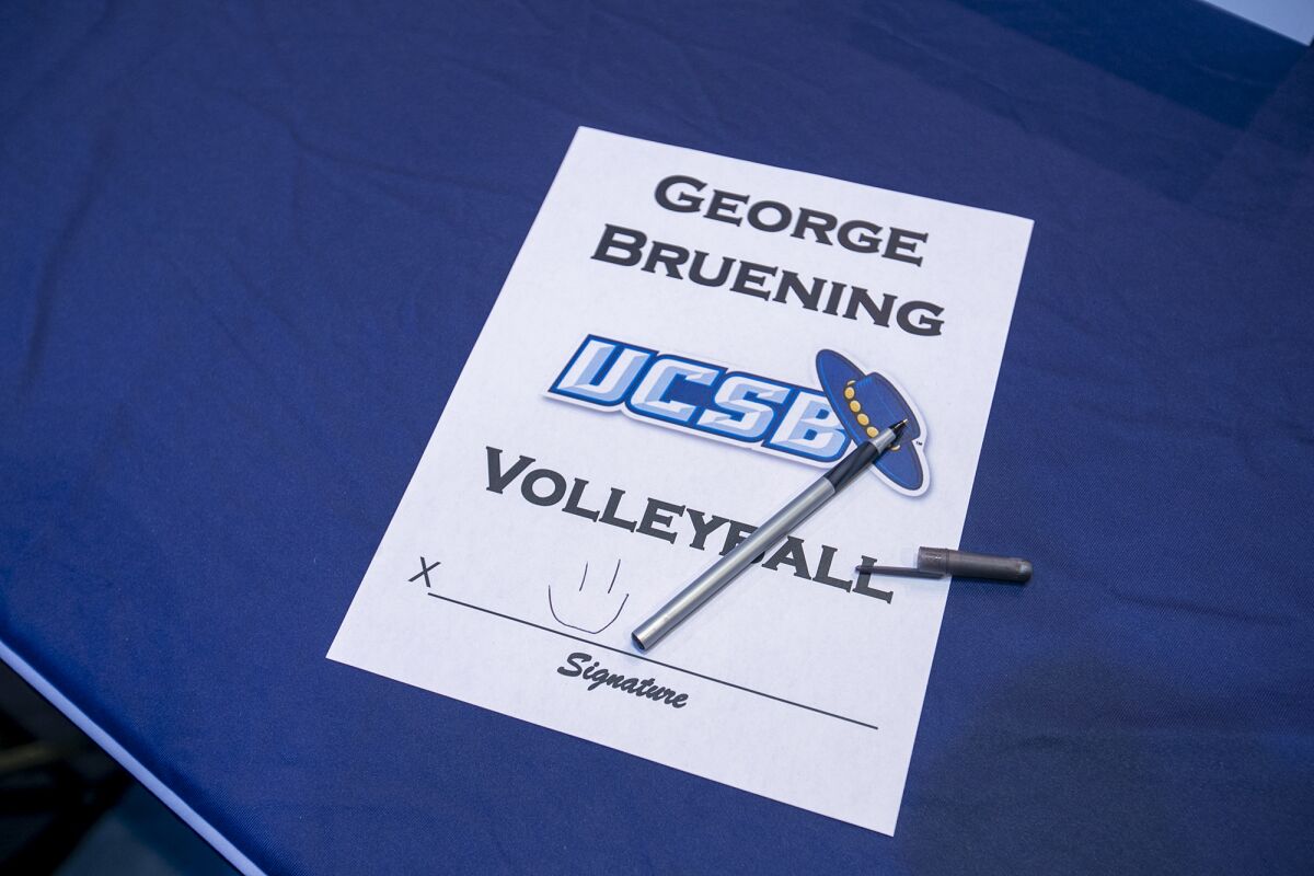 George Bruening leaves a smiley face on his signature page during Corona del Mar High School signing day on Monday.