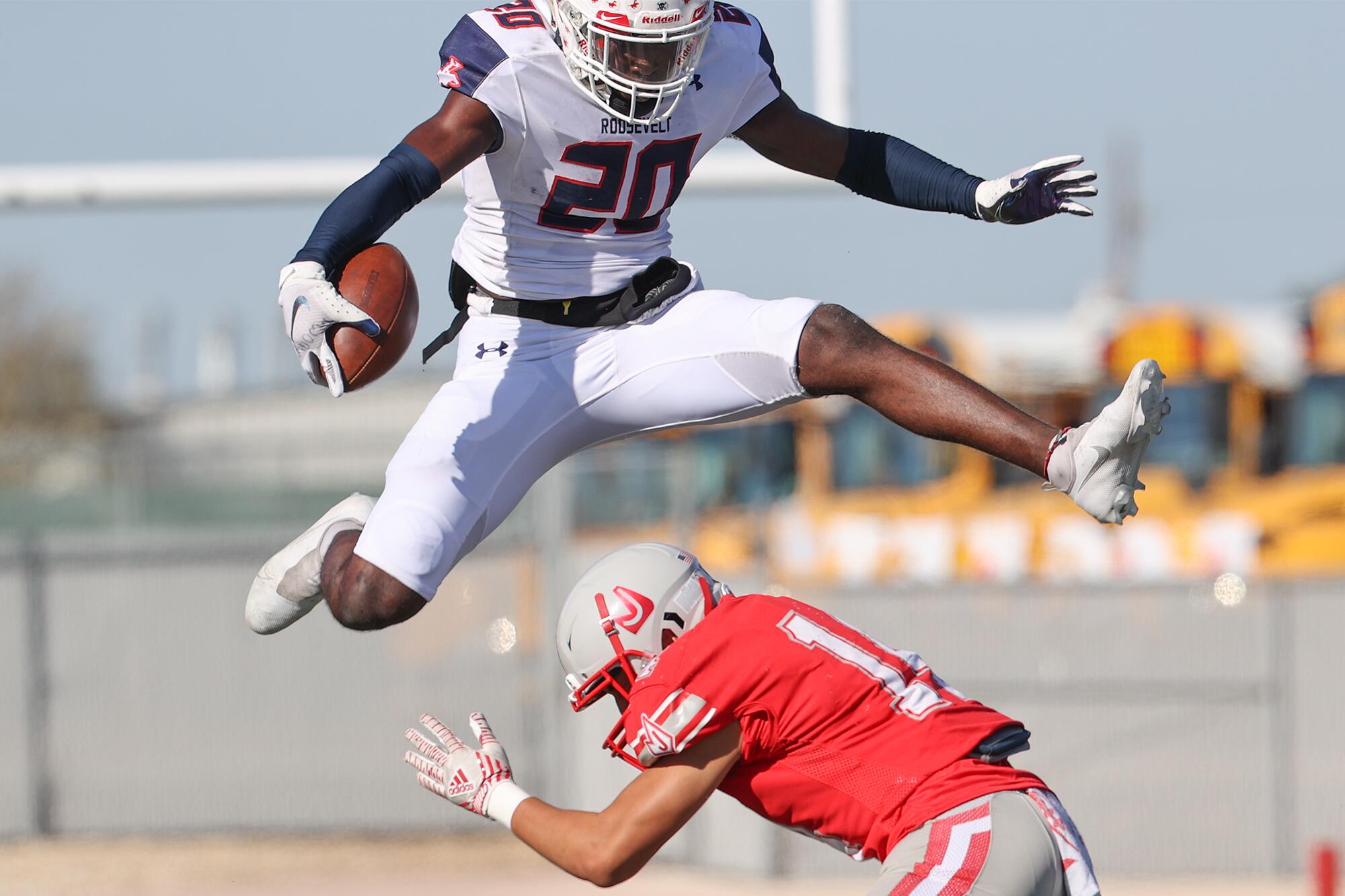 Roosevelt running back Jaylen Dears leaps over Judson's Jeffrey Bondoc 