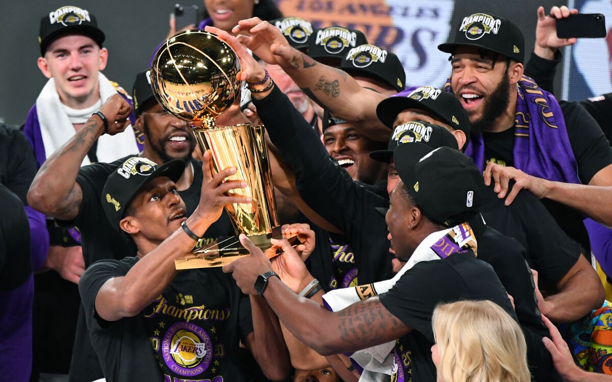 Lakers' Rajon Rondo holds the trophy after winning the NBA Championship.