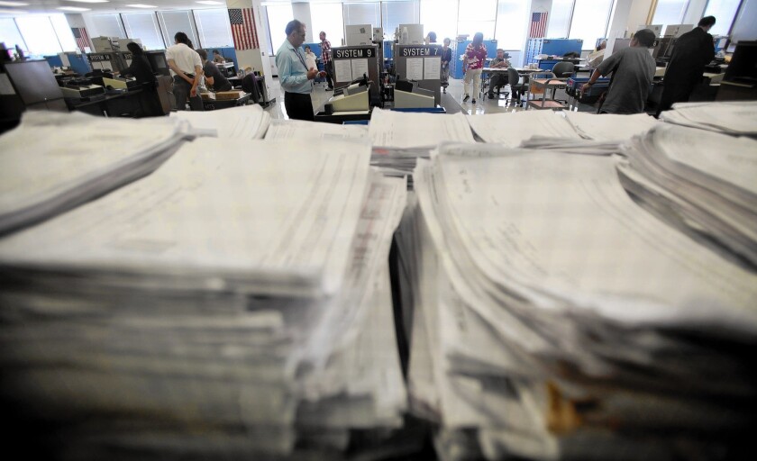 L.A. Ccounty election officials methodically load ballots into computers following election day at the County registrar-recorder's offices in Norwalk in 2012.