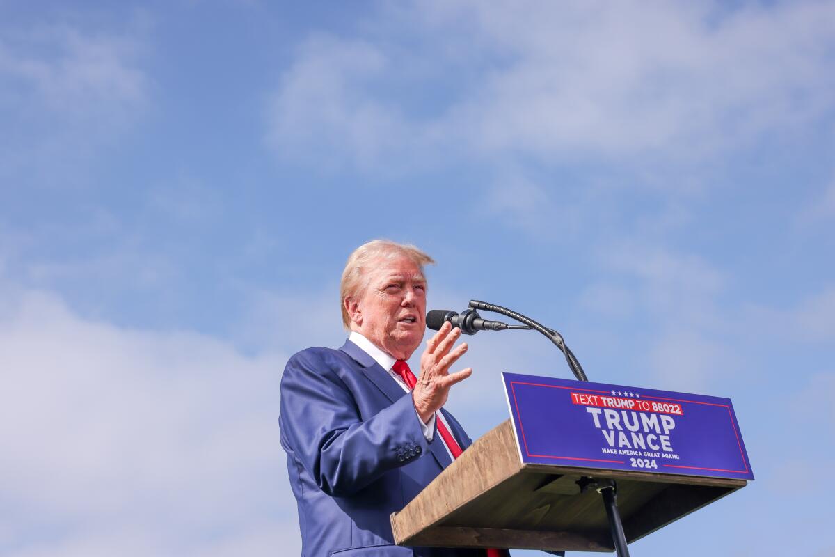 Former President Trump speaks at a lectern during a news conference. 