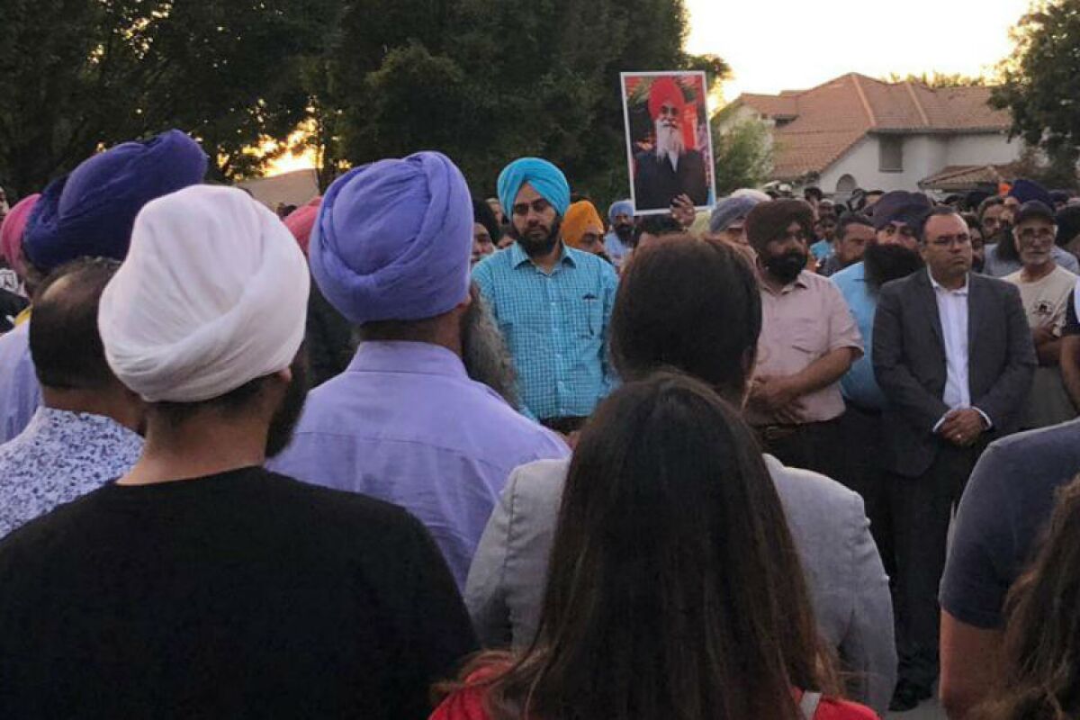 People gather at a candlelight prayer vigil for Parmjit Singh in Tracy, Calif., on Wednesday.