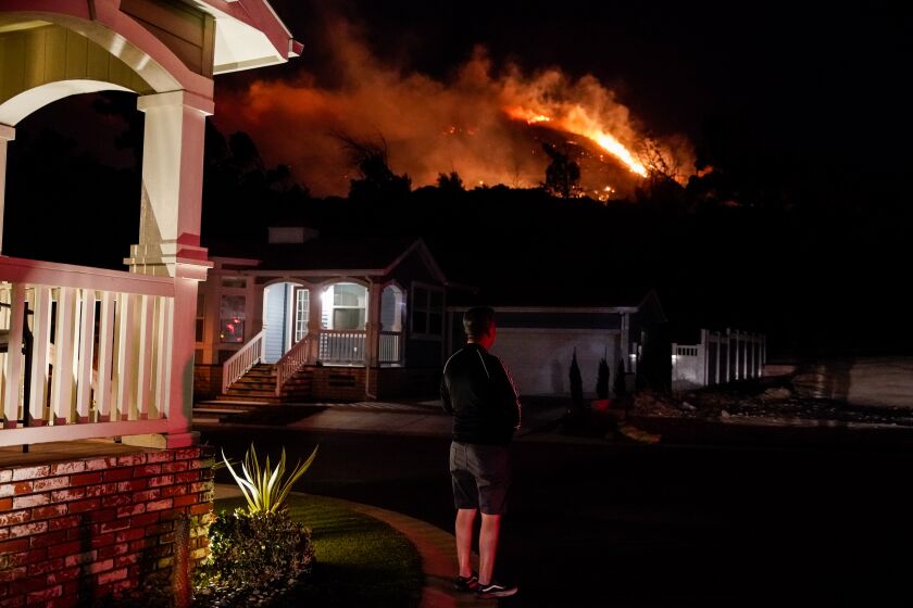 SYLMAR, CALIF. - OCTOBER 10: Oakridge Estates resident Manuel Negrete watches the Saddle Ridge Fire as people evacuate the Oakridge Estates on Thursday, Oct. 10, 2019 in Sylmar, Calif. (Kent Nishimura / Los Angeles Times)